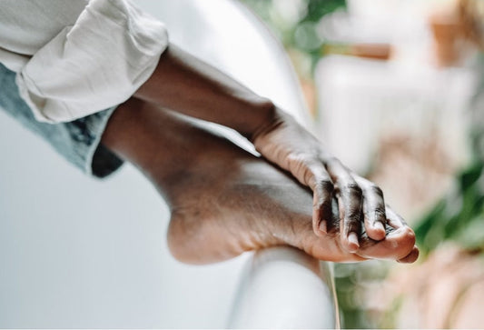 Close-up of a person's feet resting on a bathtub edge, conveying relaxation and self-care
