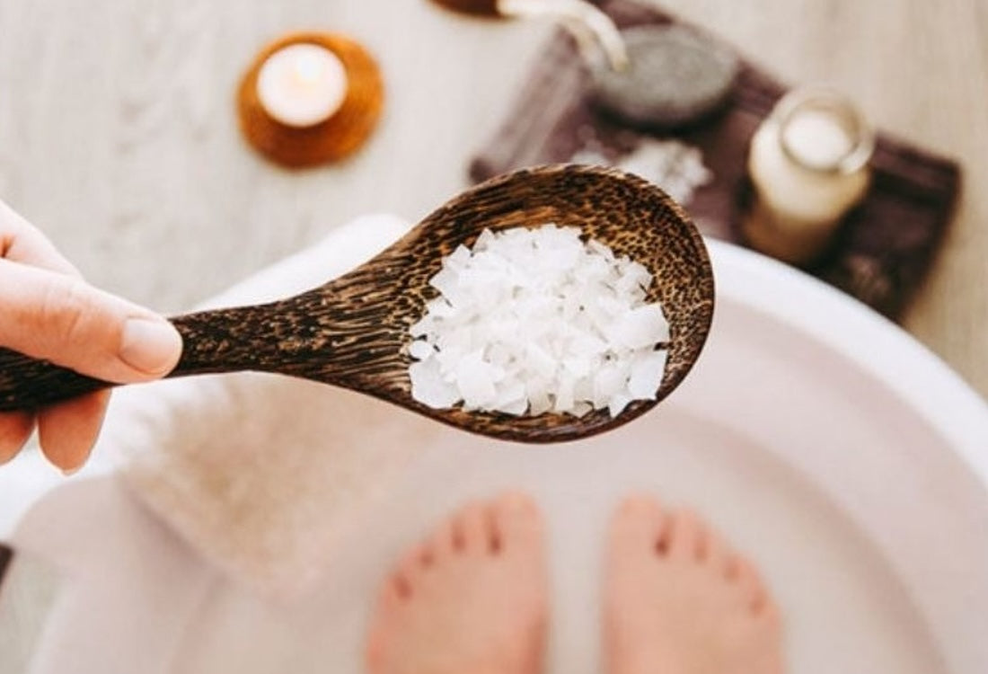 Person holding a spoon of salt for an ionic foot bath
